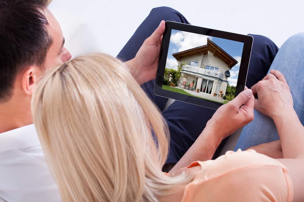 Picture of Couple Looking At House On Digital Tablet's Screen