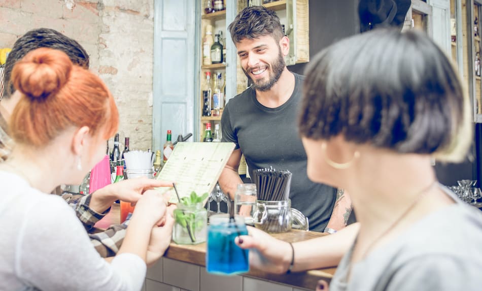 picture of group of friends choosing cocktail from the menu in a bar . concept about beverages, and people