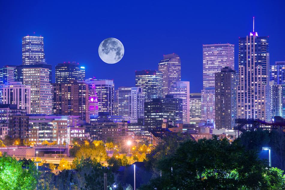 picture of Denver Colorado at Night. Denver Downtown Skyline and the Full Moon on Clear Sky.