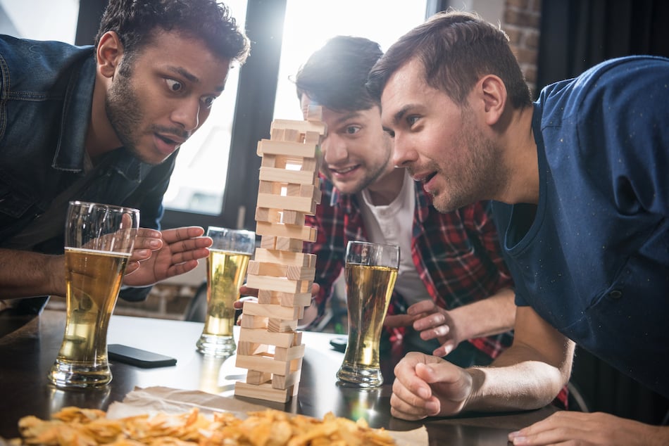 picture of a diverse group of friends playing jenga game in an austin texas bar