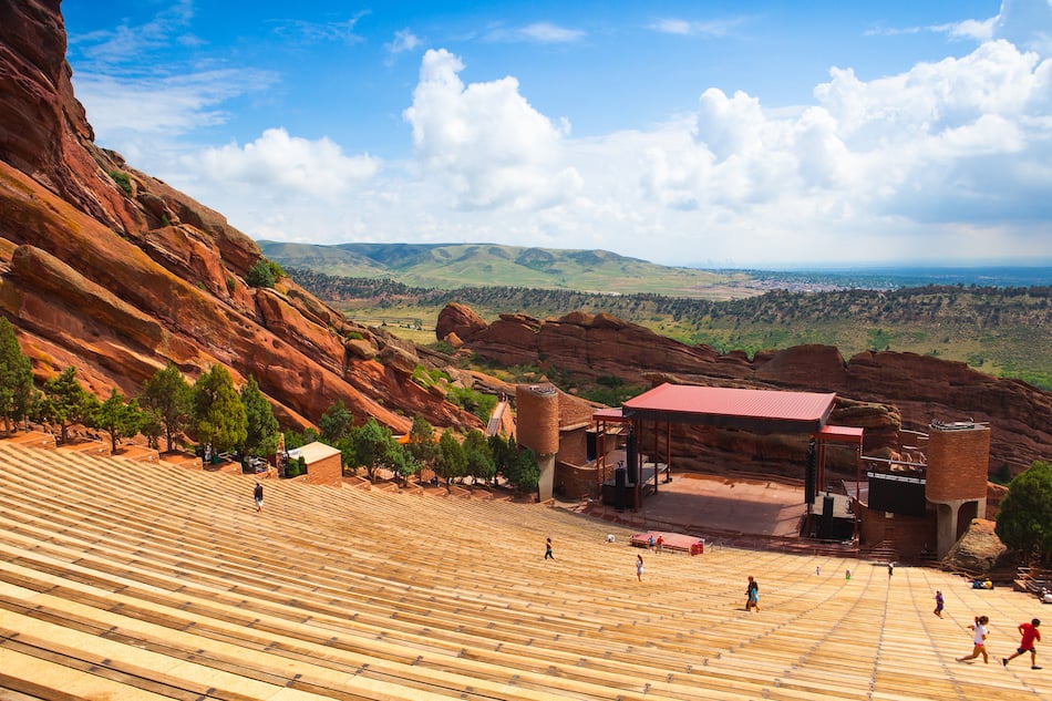 Denver, Famous Red Rocks Amphitheater in Morrison. Red Rocks Amphitheatre is a rock structure near Morrison, Colorado, 10 miles west of Denver, where concerts are given in the open-air amphitheatre.